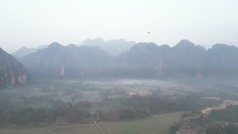 Drohnenaufnahme-Eines-Nebligen-Morgens-Im-Tal-In-Vang-Vieng,-Der-Abenteuerhauptstadt-Von-Laos