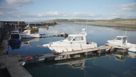 Small-Scottish-village-port,-boats,-still-water,-picturesque-scenery