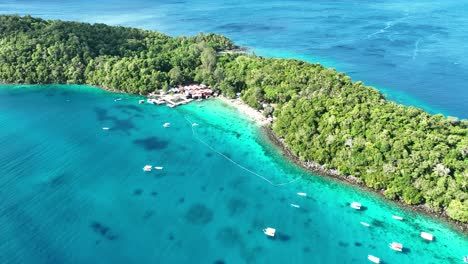 Rubiah-island,-indonesia,-showcasing-its-vibrant-blue-waters-and-dense-tropical-vegetation,-aerial-view