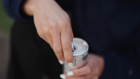 Woman-hold-and-use-fingers-to-open-sealed-carbonated-aluminium-beverage-can