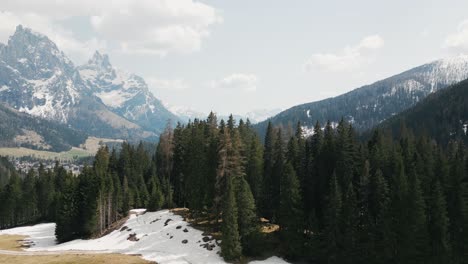 Descendiendo-Sobre-Abetos-Con-Cordillera-De-Dolomitas-Al-Fondo-En-Italia