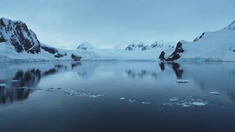 Aerial-drone-shot-of-Antarctica-Scenery,-Beautiful-Mountains-and-Glacier-Landscape-on-the-Antarctic-Peninsula-in-the-Southern-Ocean,-Winter-Seascape-of-Ocean-Snow-and-Ice-in-Cold-Weather