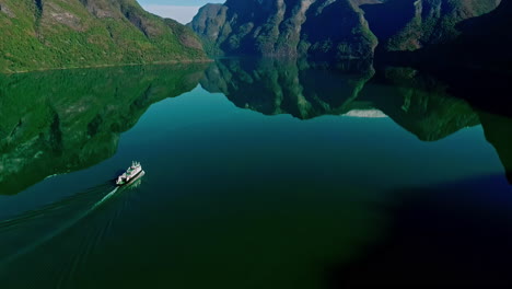 Cruise-ship-in-an-inlet-near-Flam,-Norway---landscape-reflecting-off-the-water