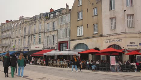 People-walking-in-an-area-with-bars-and-restaurants-in-La-Rochelle---Historic-and-old-town,-France