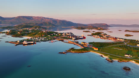 Establishing-drone-shot-of-the-Sommaroya-island-and-town,-midnight-sun-in-Norway