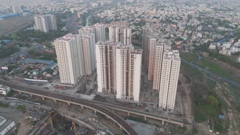 A-picturesque-drone-shot-showcasing-the-architectural-diversity-of-Chennai,-from-modern-skyscrapers-to-traditional-residential-houses,-all-set-against-a-cloudy-backdrop