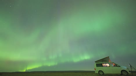 A-small-van-with-an-open-roof-tent-under-the-magnificent-aurora-skies