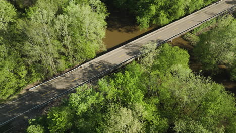 Wolf-river-winding-through-lush-greenery-with-a-bridge-in-collierville,-tn,-aerial-view