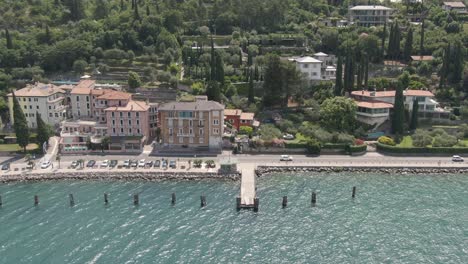 Luftaufnahme-Der-Seepromenade-Am-Gardasee-Mit-Häusern-Im-Hintergrund-Und-Autos-Auf-Der-Straße-An-Einem-Sonnigen-Tag