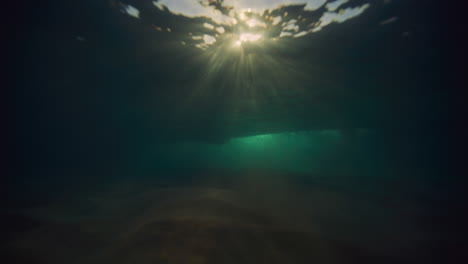 Tiefer,-Geheimnisvoller-Unterwasserhintergrund-Mit-Mystischen-Lichtstrahlen-Und-Wellen