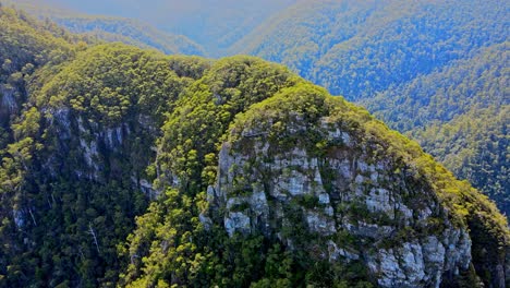 Aerial-drone-backward-moving-shot-over-mountain-range-in-Laven-Canyon,-Tasmania,-Australia-on-a-sunny-day