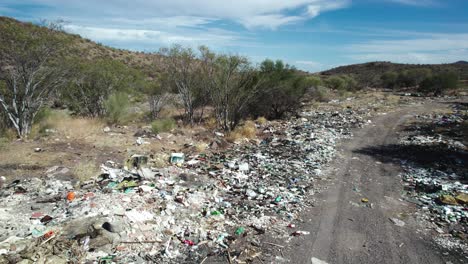 Garbage-Along-the-Road-in-Mulege,-Baja-California-Sur,-Mexico---Drone-Flying-Forward