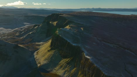 Ancient-landslip-ridges-of-Bioda-Buidhe-in-early-morning-winter-sunshine-with-reveal-of-wider-mountainous-and-moorland-landscape-beyond