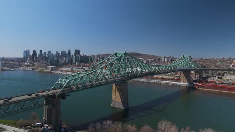 The-Jacques-Cartier-Bridge-crossing-the-Saint-Lawrence-River-from-Montreal-Island,-car-driving-connection-between-metropolitan-underground-area