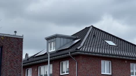 Urban-House-Villa-in-Germany-with-solar-panels-on-black-rooftop-during-clouds-at-sky