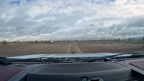 POV-Fahrt-Auf-Einem-Schotterweg-Durch-Die-Sonora-Wüste-Im-Südwesten-Von-Arizona-In-Richtung-Verstreuter-Campergruppen-An-Einem-Bewölkten-Wintertag