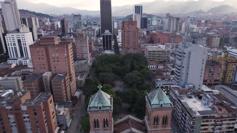 Aerial-view-of-Medellin's-Metropolitan-Cathedral,-nestled-among-modern-high-rises