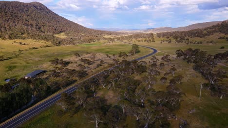 Drohnenansicht-Eines-Bauernhauses-Und-Einer-Straße-Mit-Bewölktem-Himmel-In-Crackenback,-New-South-Wales,-Australien