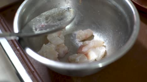 Chef-hands-thorowing-lemon-juice-in-a-bowl-for-ceviche-dish,-traditional-peruvian-food