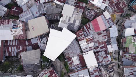 Aerial-bird's-eye-view-of-Comuna-13,-a-patchwork-of-rooftops-in-Medellin's-heart