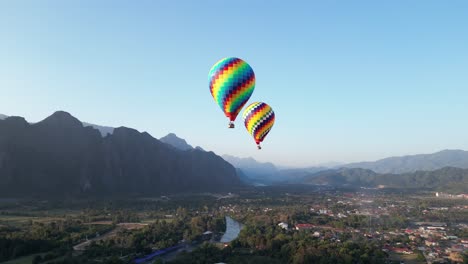 Toma-De-Drones-De-Coloridos-Globos-Aerostáticos-En-Vang-Vieng,-La-Capital-De-Aventuras-De-Laos.