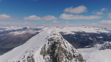 Eine-Drohne-Macht-Eine-Aufnahme-Eines-Bergsteigerteams,-Das-Den-Gipfel-Eines-Schneebedeckten-Berges-In-Italien-Erreicht