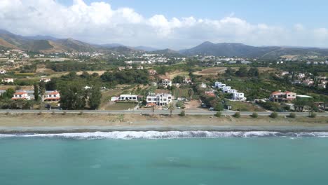 Bahía-Chrysochous-En-Chipre-Con-Olas-Golpeando-La-Orilla,-Colinas-Verdes-En-El-Fondo,-Vista-Aérea