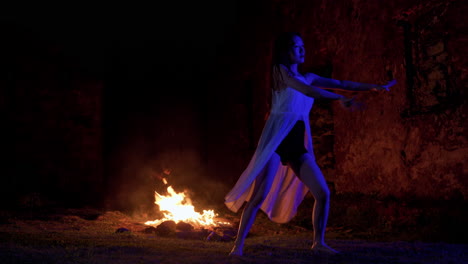 asiatic-dancer-performing-at-night-near-the-bonfire-in-woods