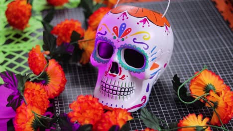 Colorido-Cubo-De-Dulces-Con-Forma-De-Calavera-Del-Día-De-Los-Muertos-Rodeado-De-Caléndulas