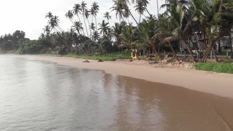 Drone-Flying-Low-Over-Sandy-Shore-of-Hiriketiya-Beach-in-Sri-Lanka