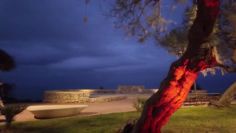 Los-Peatones-Disfrutan-Del-Paseo-Costero-Durante-La-Noche-En-Cala-Bona,-Decorado-Con-Luces.