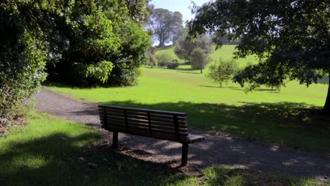 An-empty-bench-in-a-City-urban-green-park-sightseeing-sunshine-above-green-grass