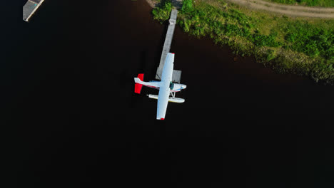Seaplane-docked-at-lake-Inari,-sunny,-summer-day-in-Lapland---Aerial-view