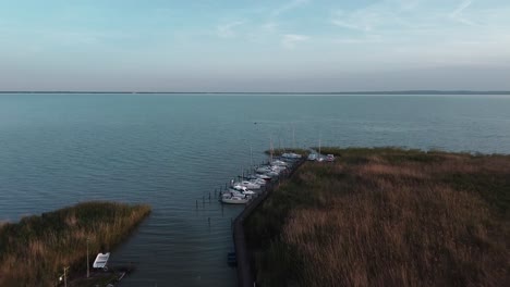 Vista-De-Drones:-Muelle-En-El-Lago-Balaton,-Veleros-Esperan-El-Viento