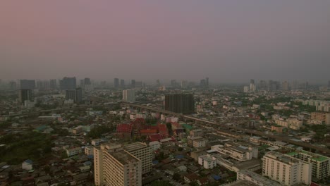 Smoggy-Bangkok-City-aerial-view,-buildings,-reversing-drone