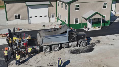 Workers-pave-new-parking-lot-beside-a-spacious-business-building-on-a-crisp-autumn-day