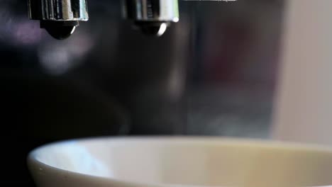 Close-up-of-Italian-Coffee-machine-with-hot-water-and-steaming-black-coffee