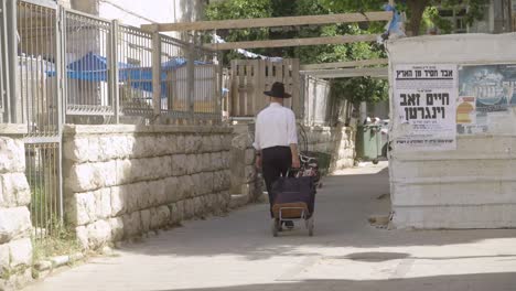 Jüdischer-Mann-Mit-Hut,-Der-In-Zeitlupe-Durch-Die-Straßen-Jerusalems,-Israels-Läuft