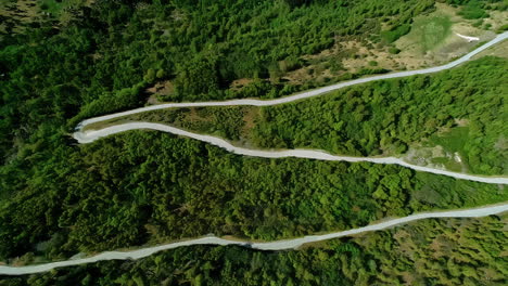 Countryside-road-near-Flam,-Norway-zigzags-along-a-mountainside---tilt-down-rising-aerial-reveal