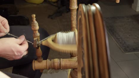 Woman-with-old-Nordic-treadle-spinning-wheel-spins-wool-into-yarn