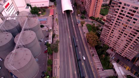 Bird's-eye-view-of-subway-car-entering-a-cylinder-shaped-station,-urban-cone,-Santiago,-Chile