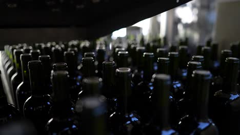 Corked-red-wine-bottles-being-moved-by-a-conveyor-belt-in-Vignonet-France,-Close-up-shot