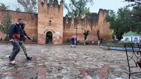 Medina-De-Chefchaouen-Bajo-La-Lluvia,-Lugareños-Y-Turistas-Caminando-En-Marruecos