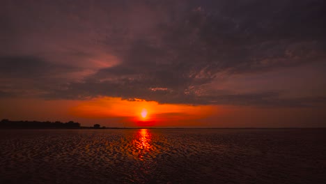 Lapso-De-Tiempo-De-La-Puesta-De-Sol-Del-Mar-De-Wadden-En-Hooksiel,-Norte-De-Alemania-Con-Nubes-Cielo-Moviéndose-Y-Reflexión