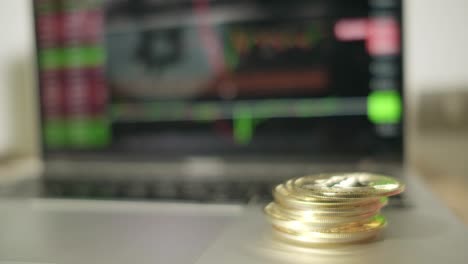 Bitcoin-Münzen-Fallen,-Handel-Auf-Dem-Online-Börsenbildschirm,-Rote-Und-Grüne-Diagramme,-Kaukasische-Finger-Halten-Geld