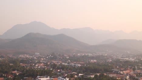 golden-glow-of-sunset-over-layers-of-hills-from-a-viewpoint-in-Luang-Prabang,-Laos-traveling-Southeast-Asia