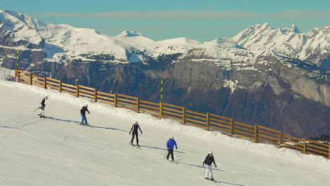 Vista-De-Perfil-De-Turistas-Esquiando-En-Las-Laderas-De-Los-Alpes-Franceses-En-Francia-Con-Un-Hermoso-Paisaje-De-Alpes-Cubiertos-De-Nieve.