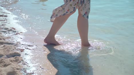 Close-up-woman-walking-legs-and-walks-into-beautiful-sea-at-beach-slow-summer