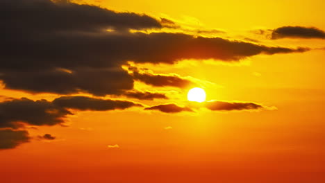 Black-clouds-sliding-into-an-orange-sky-are-covering-the-sun