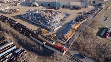 Industrial-recycling-plant-in-hamilton,-ontario-with-piles-of-scrap-metal,-sunny-day,-aerial-view